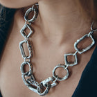 Close-up of a person wearing a silver chain necklace.