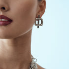 Close-up of a woman wearing silver jewelry with a light blue background