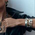 Woman wearing a black leather jacket with silver jewelry against a light background
